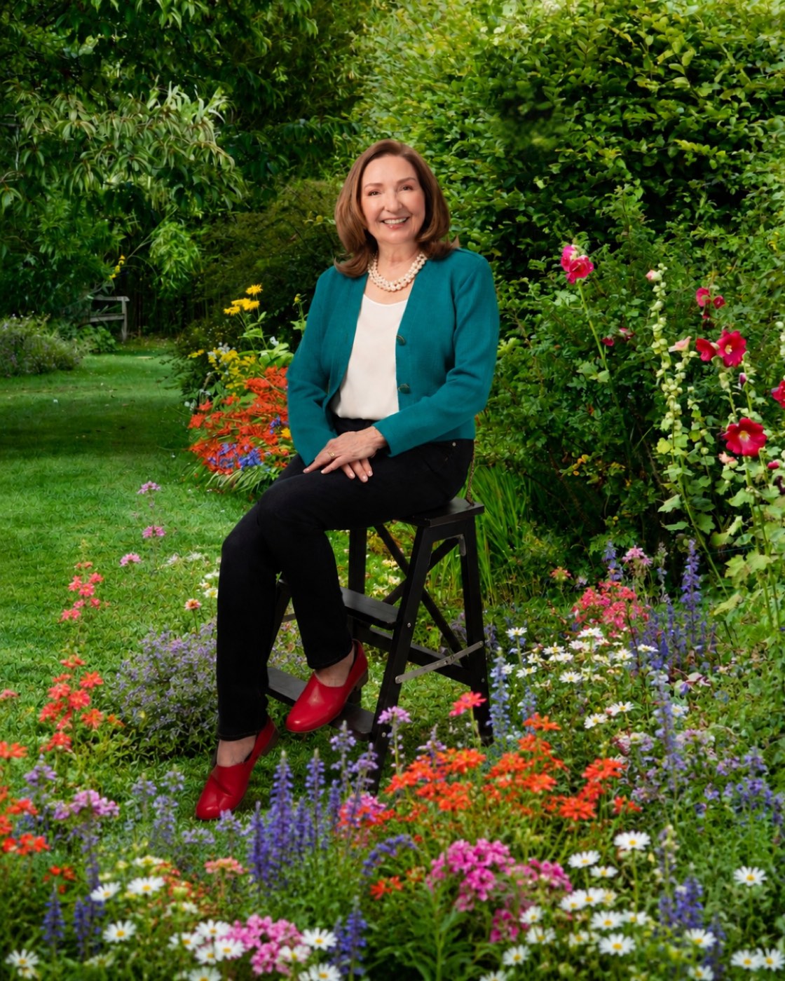 Ann Landers, Licensed Marriage and Family Therapist, seated on a step stool in a flowering garden